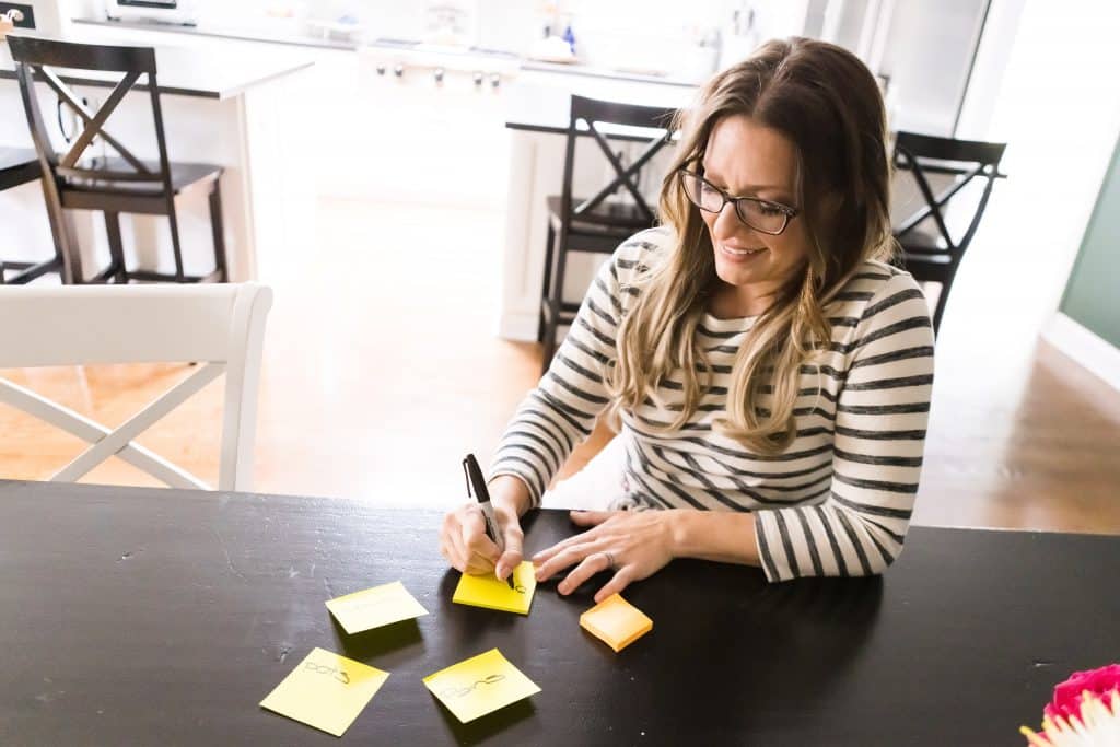 The Organizing Mama writing labels on Post It notes