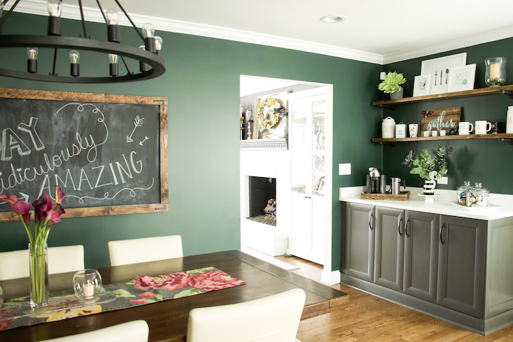 Kitching and dining room in dark, moody green color against dark moody purple color of living room. Dark kitchen space creates a cozy feel. #kitchendecor #modernfarmhousedecor