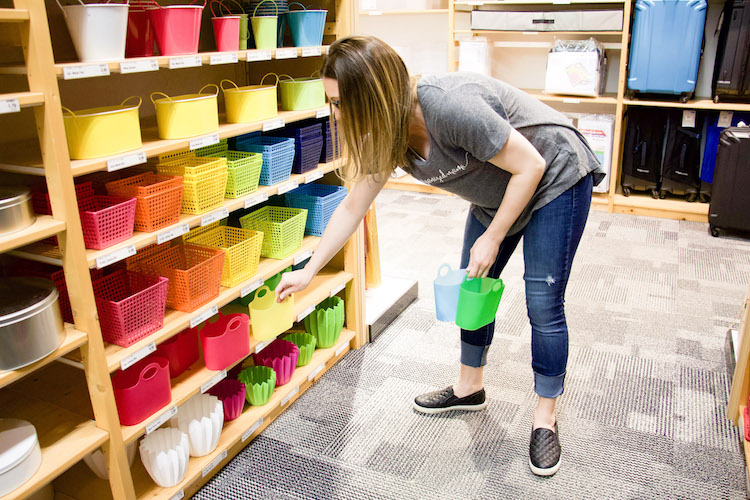professional organizer shopping at the container store in the party aisle holding mini party totes