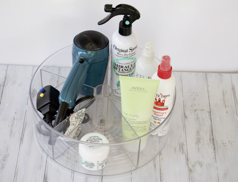 turntable with bathroom supplies include hair sprays and hair dryer #bathroomorganization