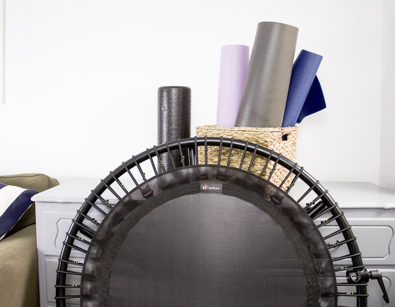 baskets with yoga mats and bellicon rebounder stored in basement