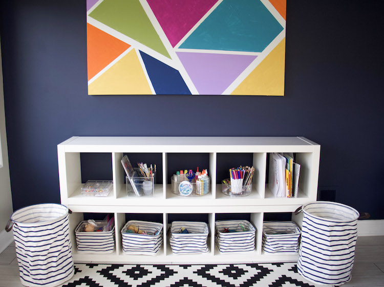 play room with colorful artwork and bins for toys