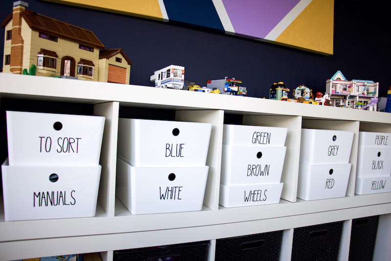 sorting legos on shelving with lego creations on top of shelving