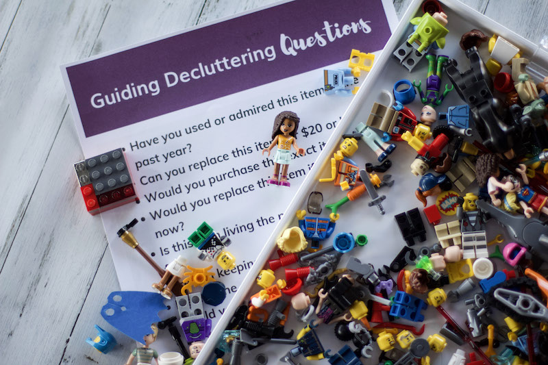 Guided decluttering questions cheat sheet with lego people laying over #organized #declutter