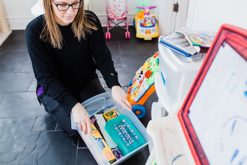 mom putting away kids toys during a 15 minute tidy of her home #tidy #organized