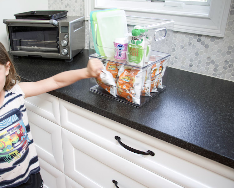 child reaching for snacks on countertop snack station