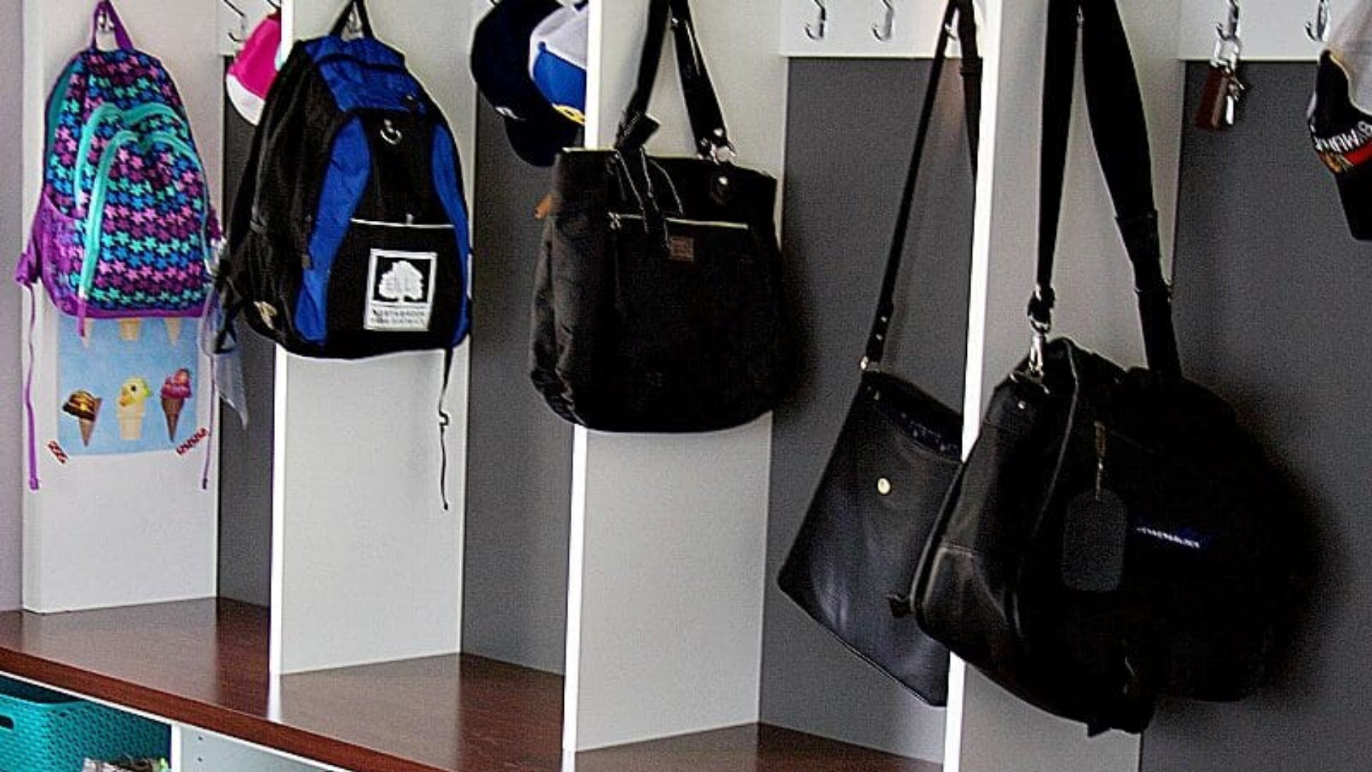 Bags hanging on hooks in mudroom #mudroomorganization