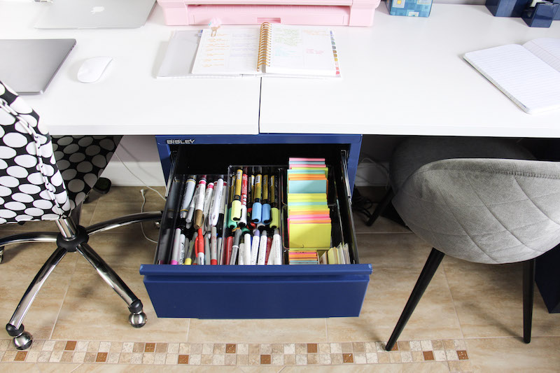 desk drawer with post it notes and sharpie markers