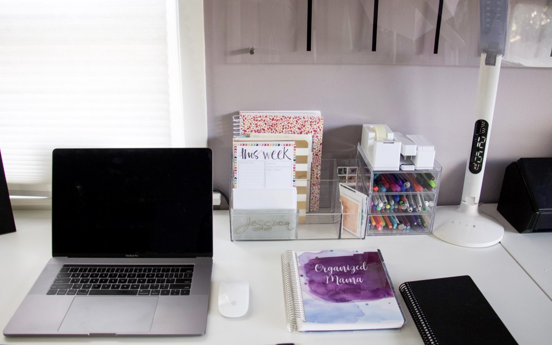 office in small space desk set up with computer and planner on long but narrow desk