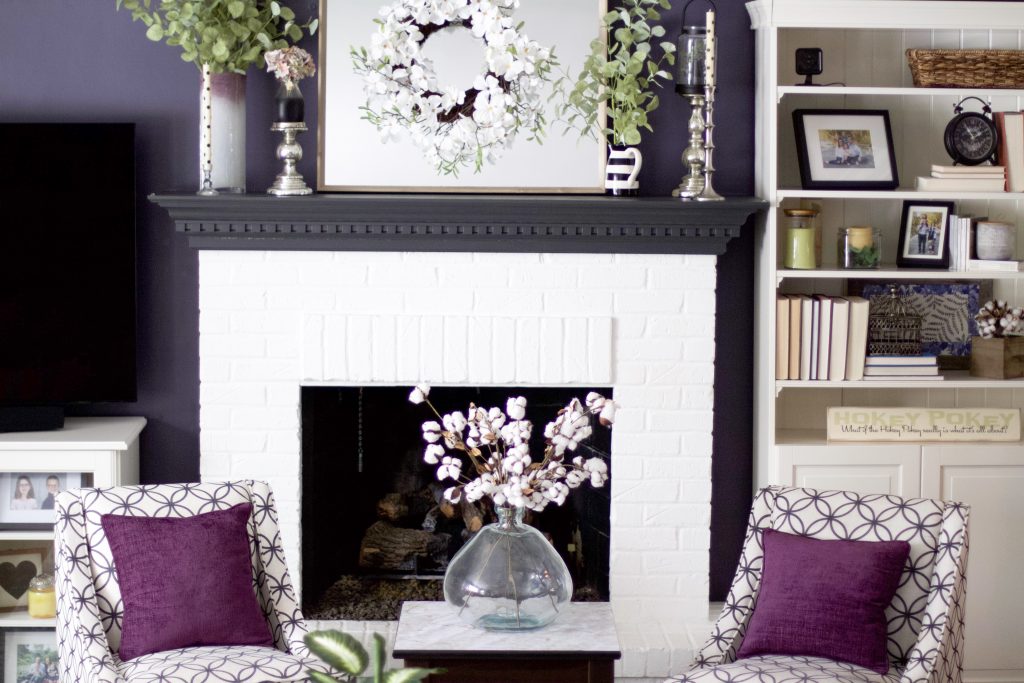 living room with mantel decor and chairs in front of fire place