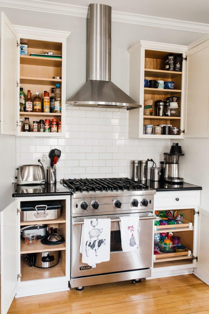kitchen stove with cabinets and doors open with everything organized on shelves and in cabinets