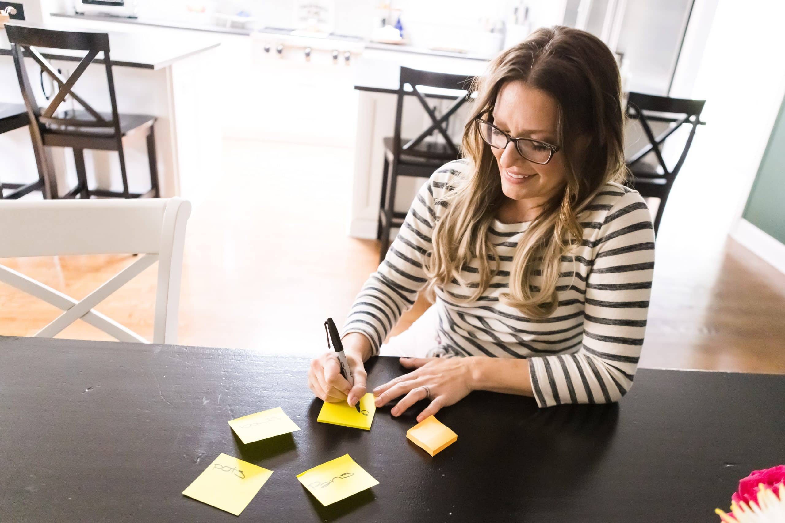 The Organizing Mama writing labels on Post It notes