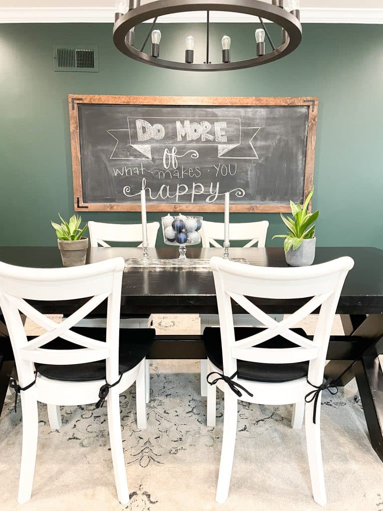 dining room with oversized chalkboard that says do more of what makes you happy