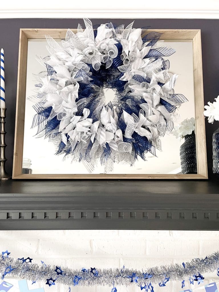 hanukkah wreath with blue, white and silver deco mesh hanging over mirror