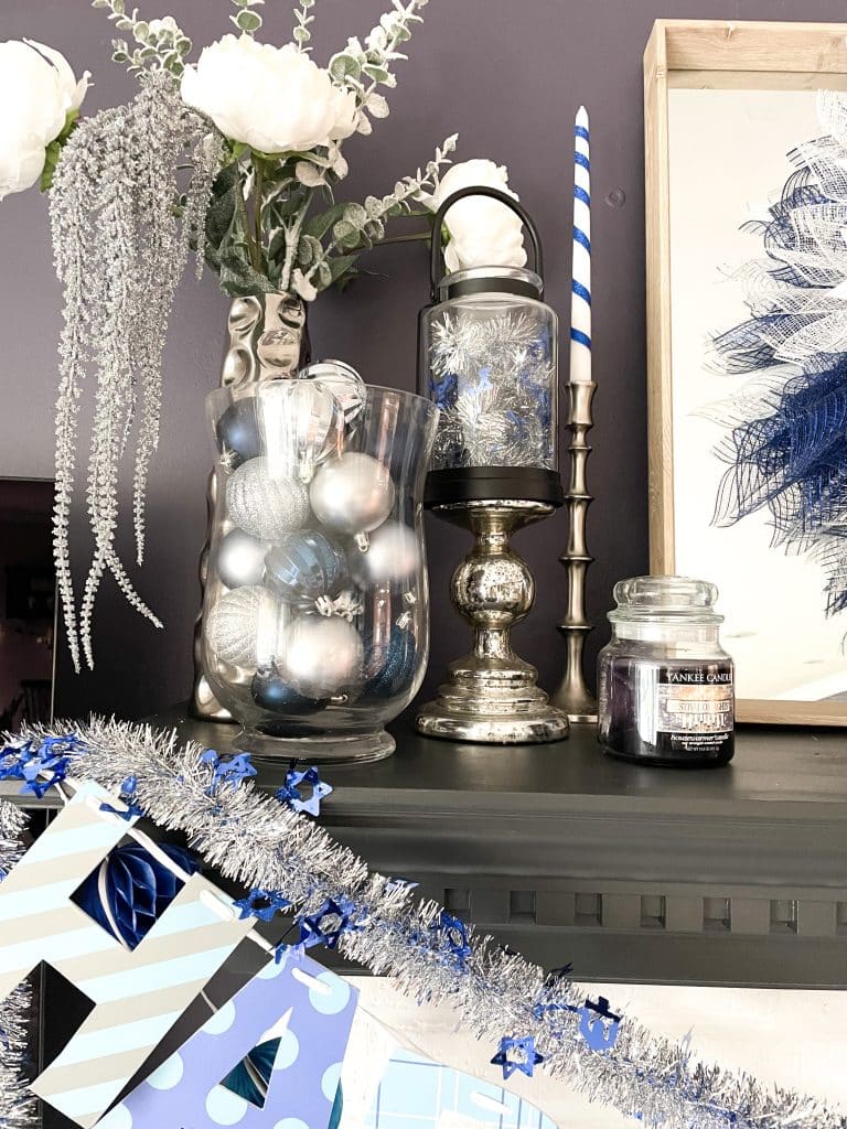 jars filled with blue and silver balls and candles wrapped in blue ribbon for hanukkah