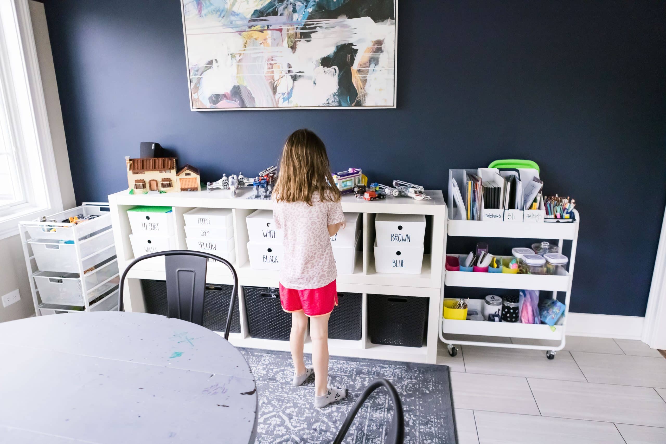 girl putting away toys