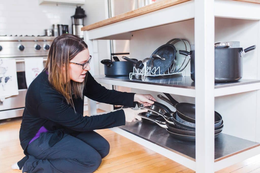 organizing pots and pans under a movable kitchen island