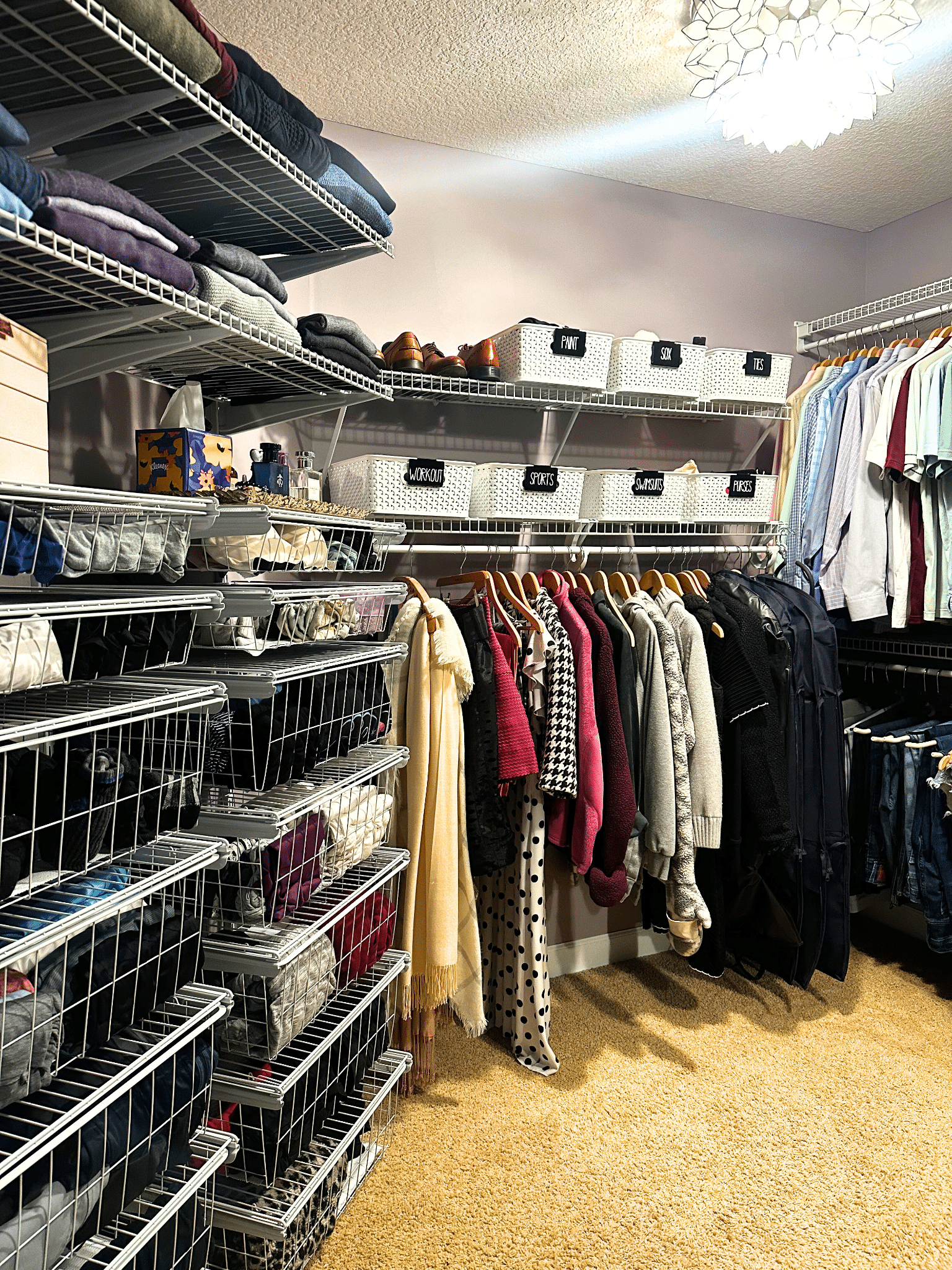 Walk in closet with wire drawers and hanging clothing items