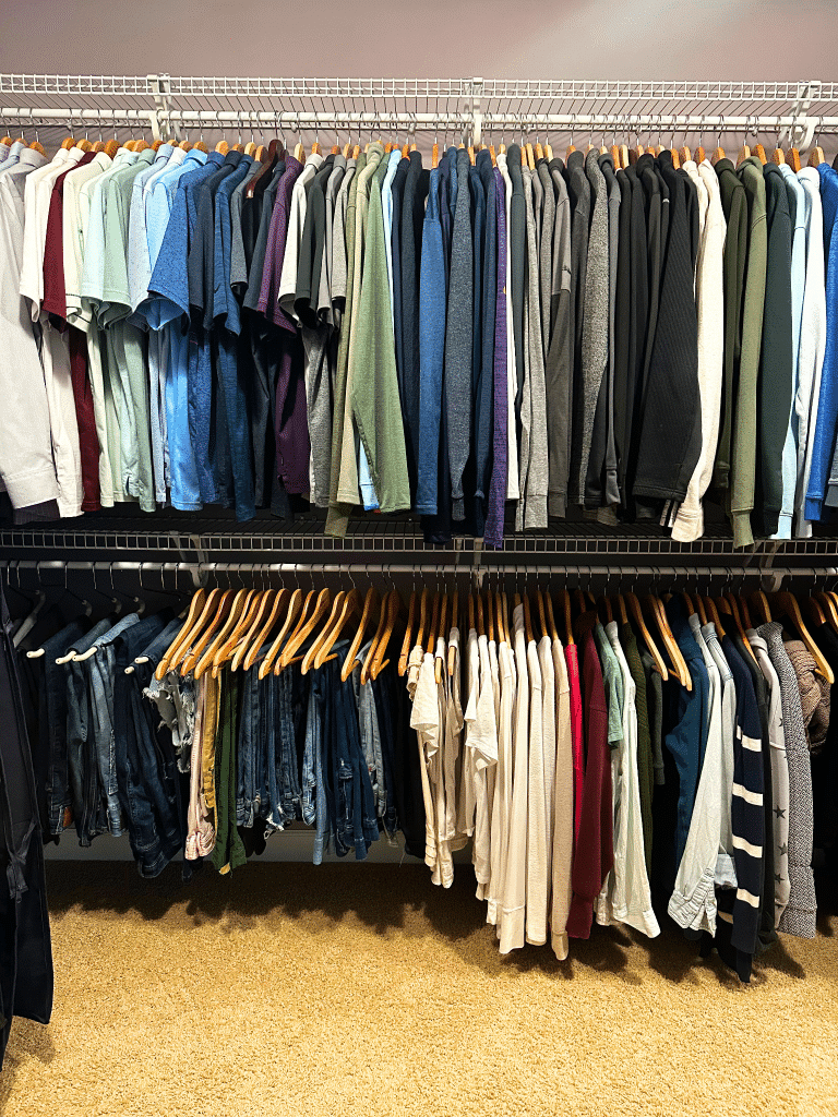 walk in closet with two rows of hanging clothing items